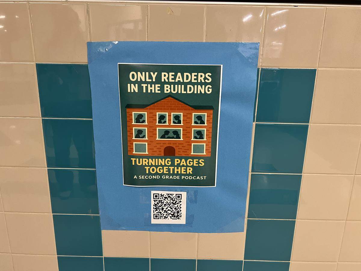 A poster advertising the podcast, “Only Readers in the Building – Turning Pages Together,” is seen in the hallway of Heritage Elementary School in Grapevine-Colleyville ISD on Thursday, March 12, 2026. Second-grade students discuss books they’re reading on the podcast twice a week.