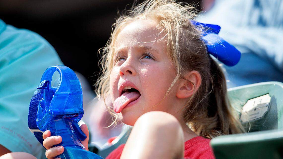 Texas Rangers fan Gianna Styles, 6, tries to cool off in the 97-degree heat during the sixth inning of Sunday's game against the Houston Astros at Globe Life Park.