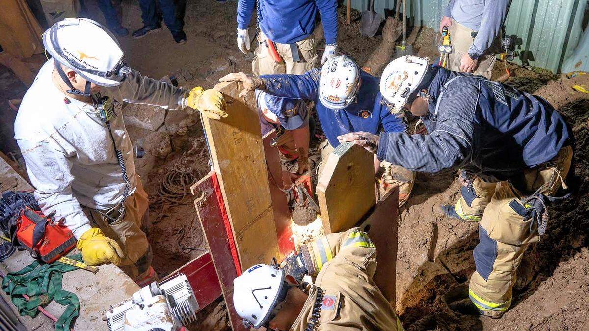 Two workers who were trapped for more than an hour Monday night while trying to fix a leak under Treetops School International in Euless were rescued by firefighters.