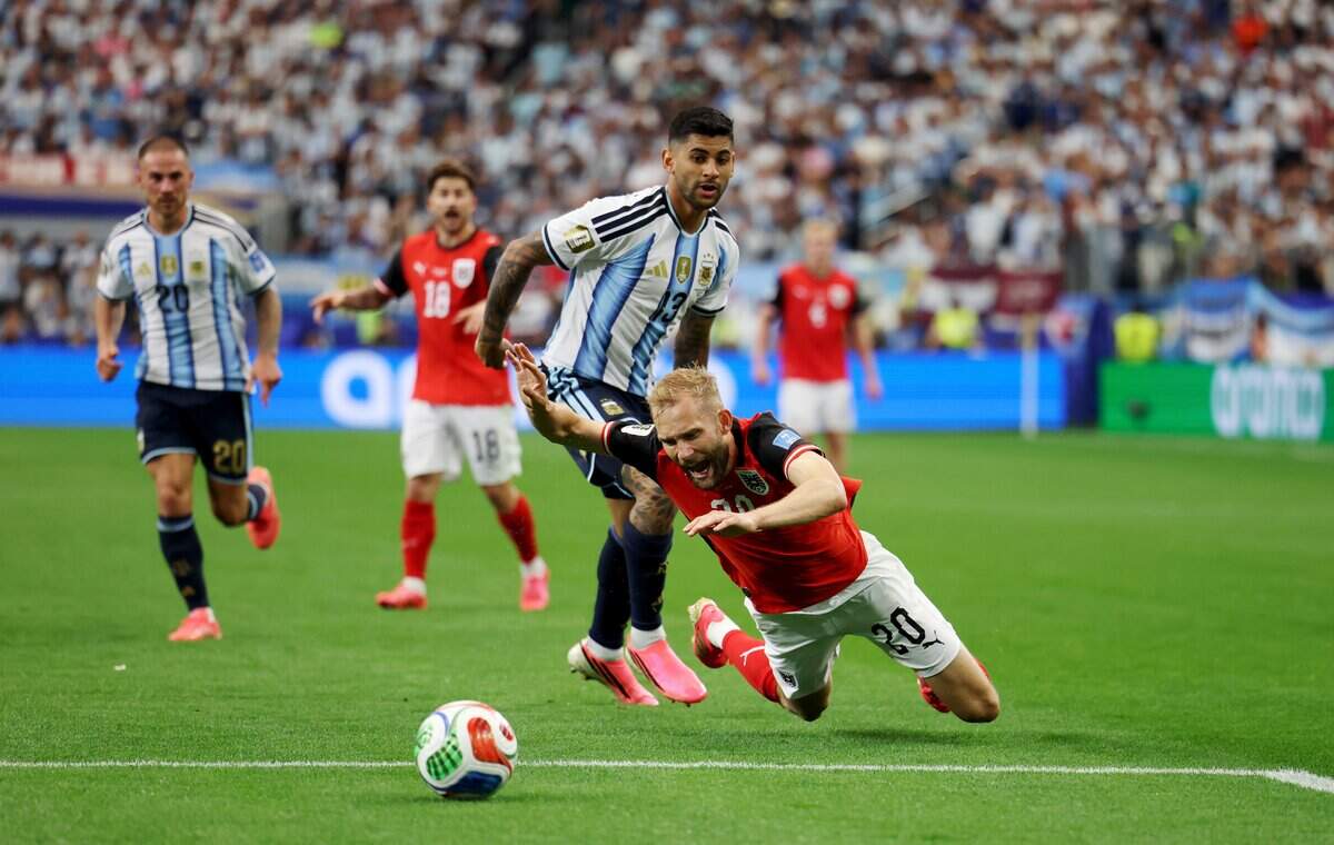 Austria midfielder Konrad Laimer falls to the grass while being defended by Argentina's Cristian Romero during a FIFA World Cup 2026 matchup on Monday, June 22, 2026, at Dallas Stadium in Arlington.