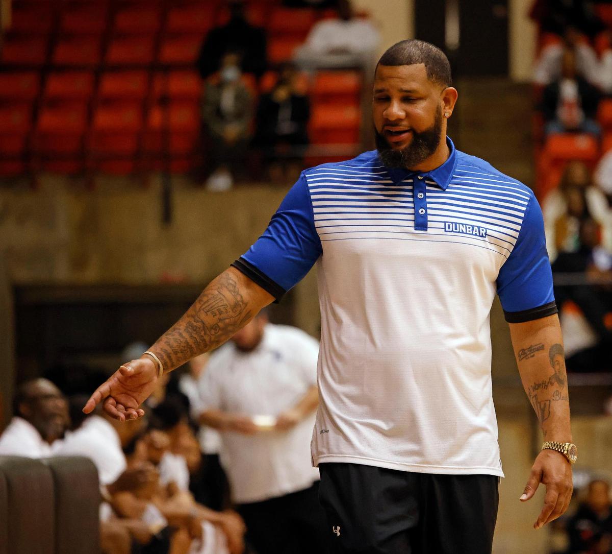 Dunbar head coach Swarn Lacy talks to a player on the bench in the fourth quarter of a high school basketball game at Wilkerson Greines Activity Center in Fort Worth, Texas, Saturday, Jan, 27, 2024.