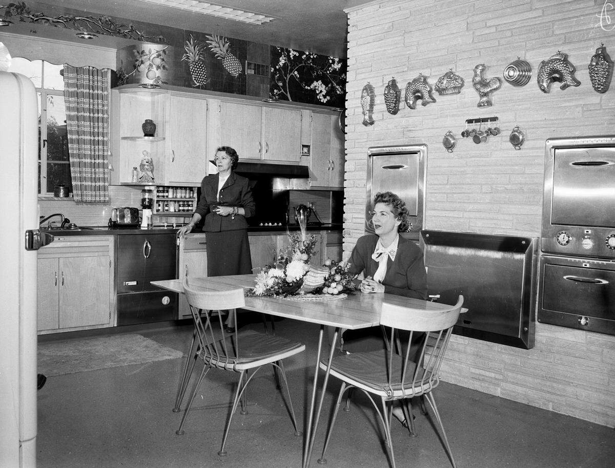 April 5, 1955: Mrs. Richard C. Newkirk and Mrs. Robert P. Woltz in the kitchen of Mr. and Mrs. W. A. Moncrief’s home.