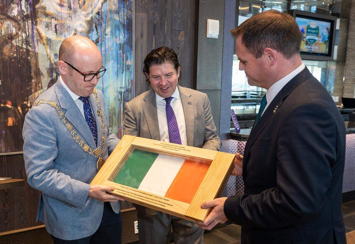 Lord Mayor of Dublin Ray McAdam, left, and Irish Deputy Foreign Minister Neale Richmond, right, present TCU Chancellor Daniel Pullin with an Irish flag. A delegation from Ireland visited TCU on Oct. 3, 2025, to discuss TCU’s appearance in the 2026 Aer Lingus College Football Classic.