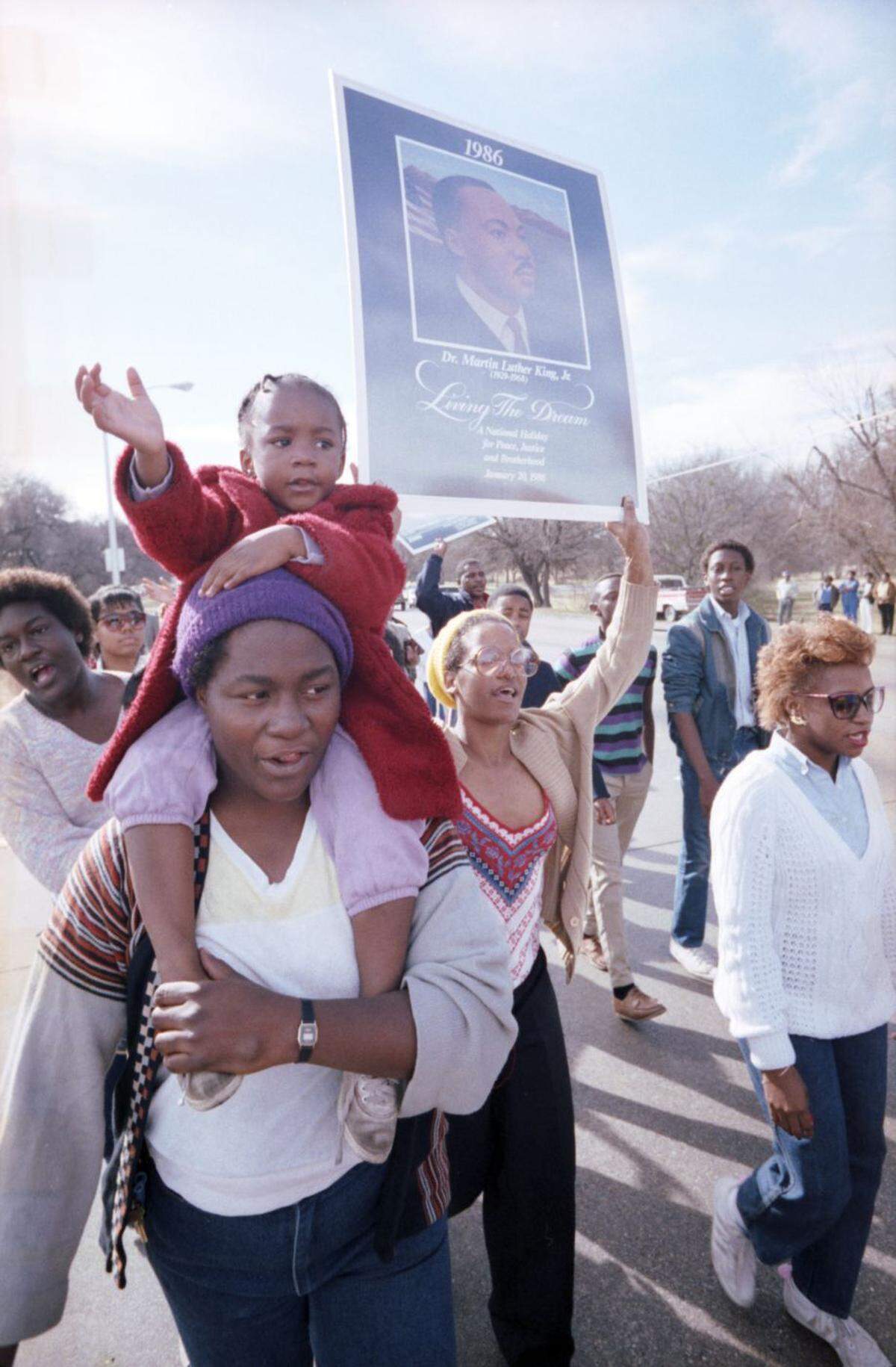 Jan. 15, 1986: Latoya Jones, 4, rides atop the shoulders of her mother, Mary Jones, during a memorial march along East Rosedale Street in Fort Worth for civil rights leaders Martin Luther King Jr.
