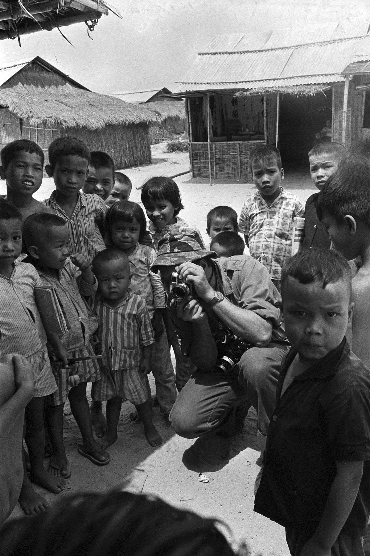 Associated Press photographer Eddie Adams takes photos of a group of Vietnamese children, 1966.