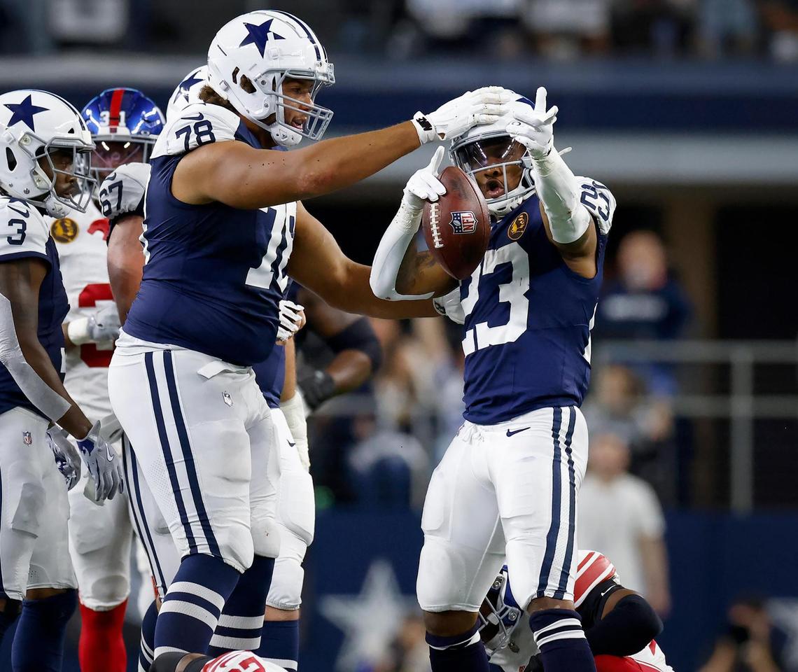 Dallas Cowboys running back Rico Dowdle (23) celebrates a play with teammate Terence Steele (78) while competing against the New York Giants on Thursday, Nov. 28, 2024, at AT&T Stadium in Arlington.