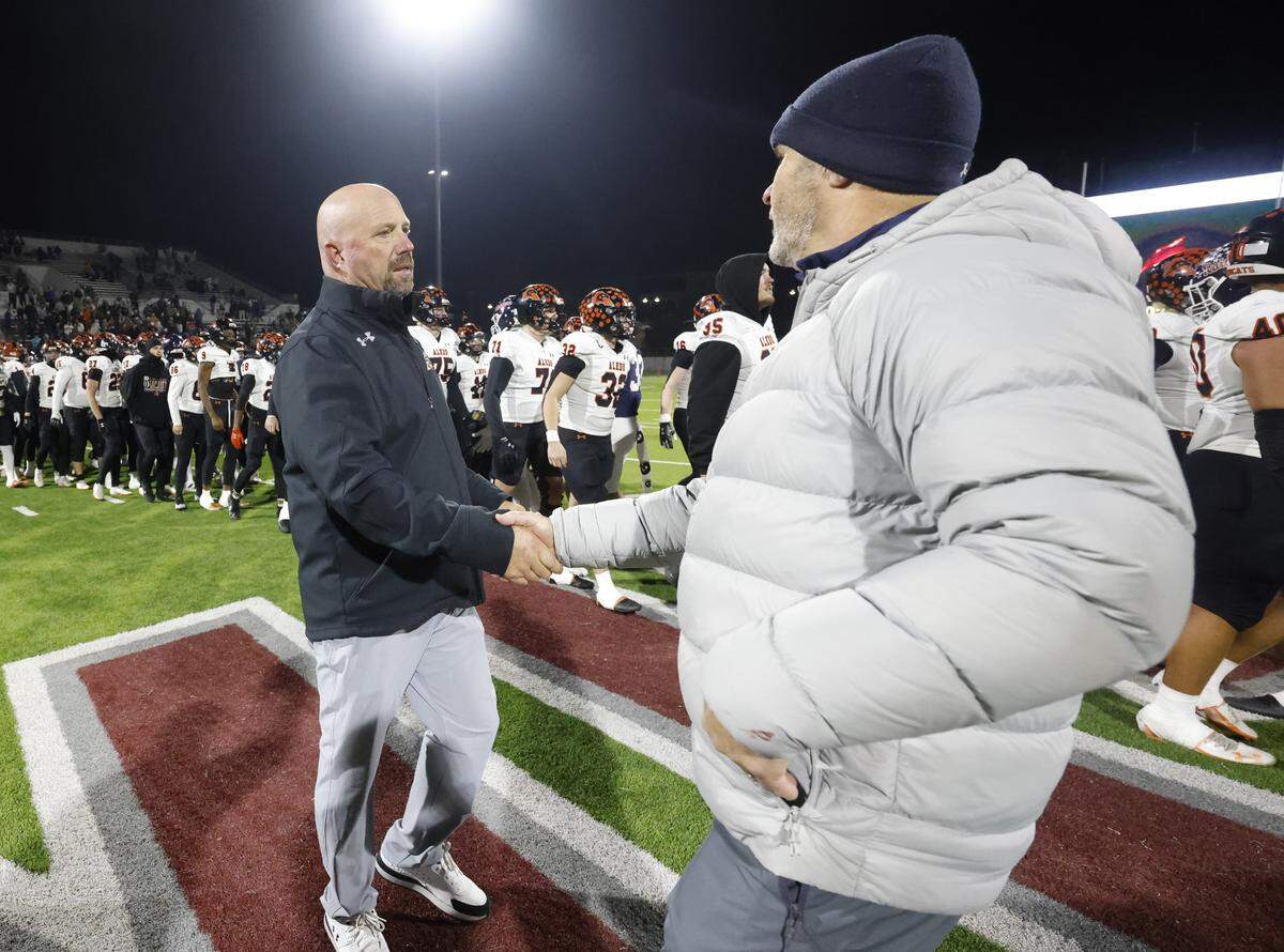 Aledo head coach Robby Jones and Denton Ryan head coach Dave Henigan meet at mid field after their UIL Class 5A Division I Quarterfinal on Friday Dec. 05, 2025 at Northwest ISD Stadium in Fort Worth, Texas.