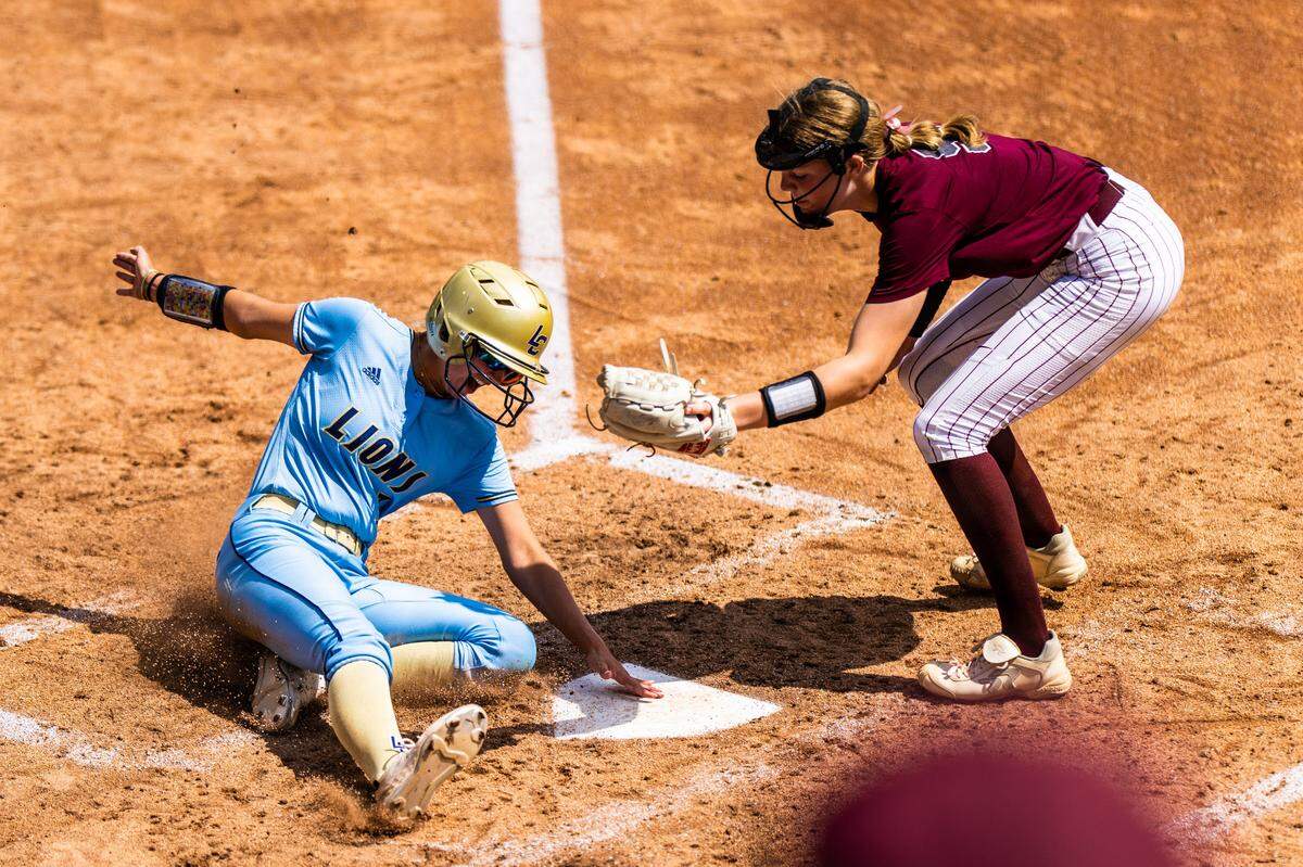 Montgomery Lake Creek’s Payton Bauer, left, scores on a wild pitch under the tag of Frisco Heritage pitcher Jensin Hall in the fourth inning of a Class 5A state semifinal on Friday, June 2, 2023 at McCombs Field in Austin, TX.