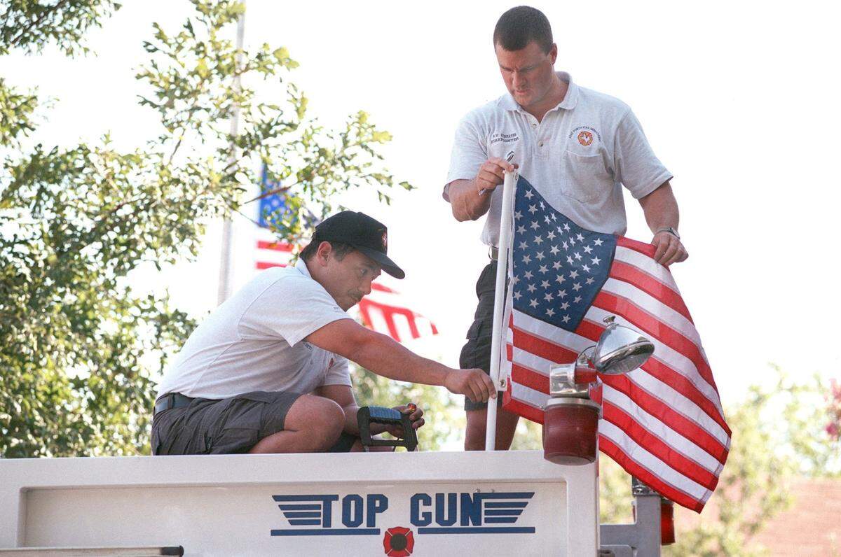 Fort Worth firefighters Frank Becerra, left, and Scott Streater install a flag atop Engine 5 on Sept. 12, 2001, in honor of their fallen brothers and sisters in the FDNY.