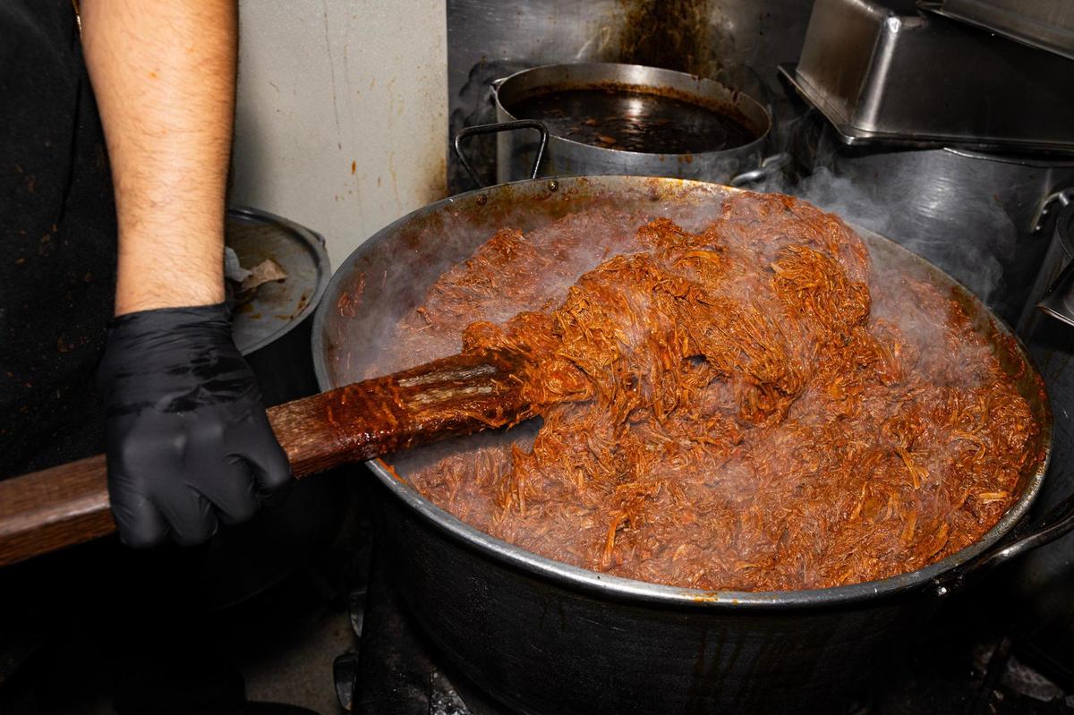 Birria is stirred after stewing for hours in the pot at Birrieria y Taqueria Cortez in Fort Worth on Wednesday, Nov. 20, 2024. The restaurant earned a Michelin Recommended rating, landing the taqueria on a prestigious list of eateries around the nation.