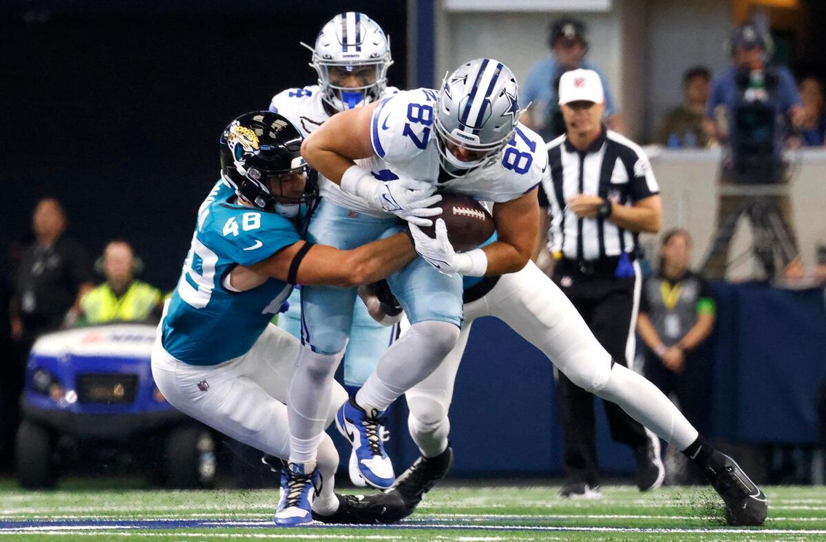 Dallas Cowboys tight end Jake Ferguson runs for yards while being held back by Jacksonville Jaguars linebacker Chad Muma on Saturday, August 12, 2023, at AT&T Stadium in Arlington.