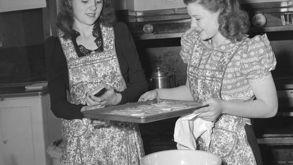 Two high school students who lived at the Scott Mansion baked biscuits in the home’s spacious kitchen in November 1941. Cooking was part of their training with the Girls Service League, which owned the landmark for more than three decades.