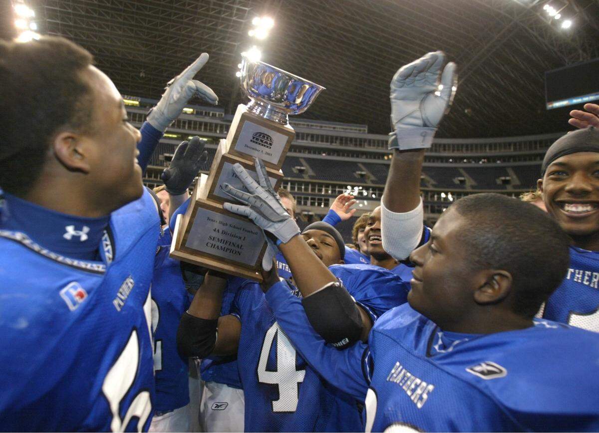 North Crowley players hold up their trophy in celebration after their playoff victory over Texas High School at Texas Stadium. North Crowley advances to the State 4A championship game. Photo taken on Friday, December 5, 2003 (FWST/Kelley Chinn)