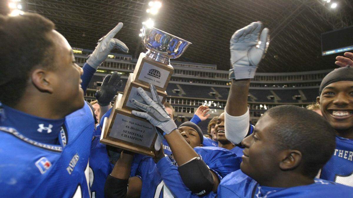North Crowley players hold up their trophy in celebration after their playoff victory over Texas High School at Texas Stadium. North Crowley advances to the State 4A championship game. Photo taken on Friday, December 5, 2003 (FWST/Kelley Chinn)
