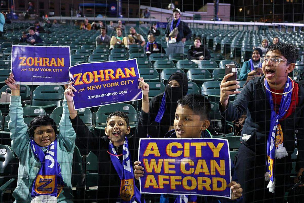 Boys cheer holding campaign posters of Democratic candidate for Mayor of New York City Zohran Mamdani as he hosts "The Cost of Living Classic" soccer tournament of NYC Footy soccer league on October 19, 2025 in New York City. (Photo by ANGELA WEISS / AFP) (Photo by ANGELA WEISS/AFP via Getty Images)