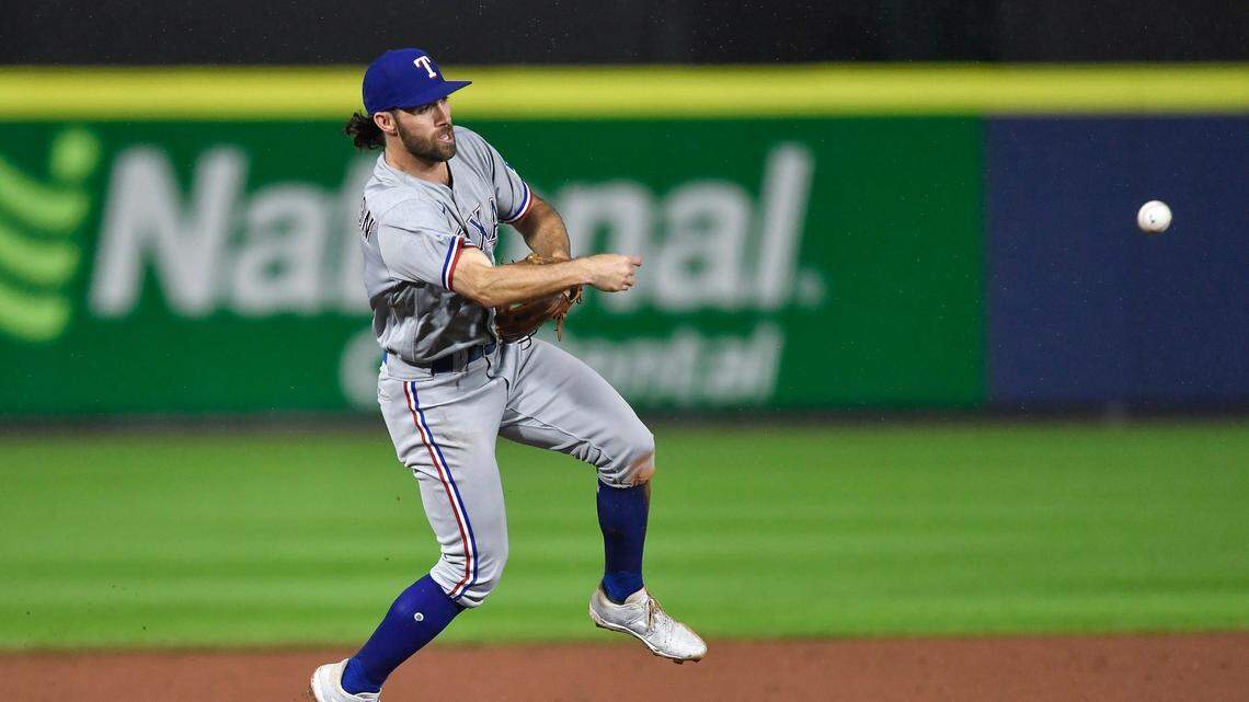 Texas Rangers third baseman Charlie Culberson throws to first after fielding a grounder hit by Toronto Blue Jays’ Lourdes Gurriel Jr., who was out during the seventh inning of a baseball game in Buffalo, N.Y., Friday, July 16, 2021. (AP Photo/Adrian Kraus)
