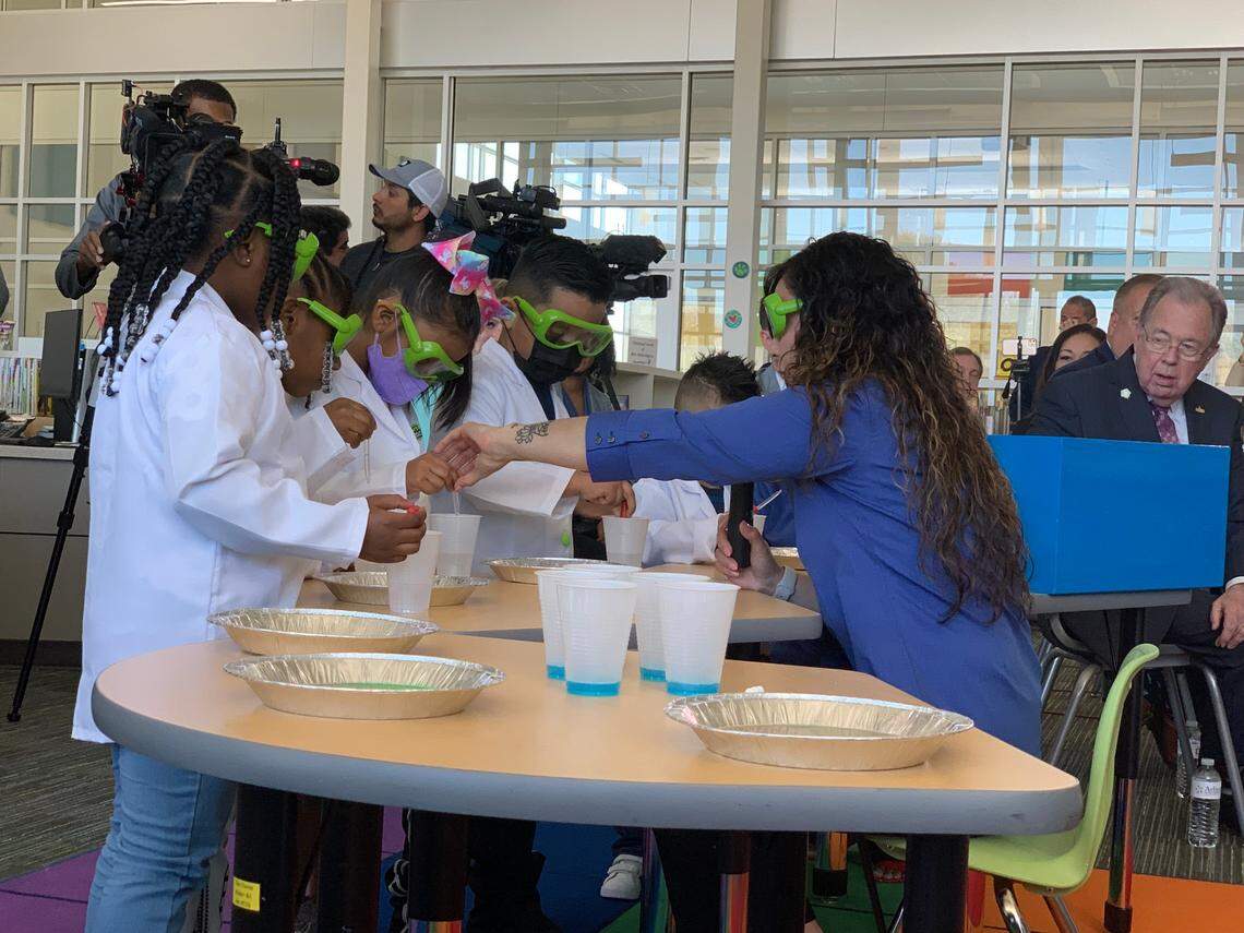 Pre-K students at McNutt Elementary School in Arlington demonstrate a science experiment using colors and dish soap at a ceremony announcing the expansion of preschool to all 4-year-olds in the district.