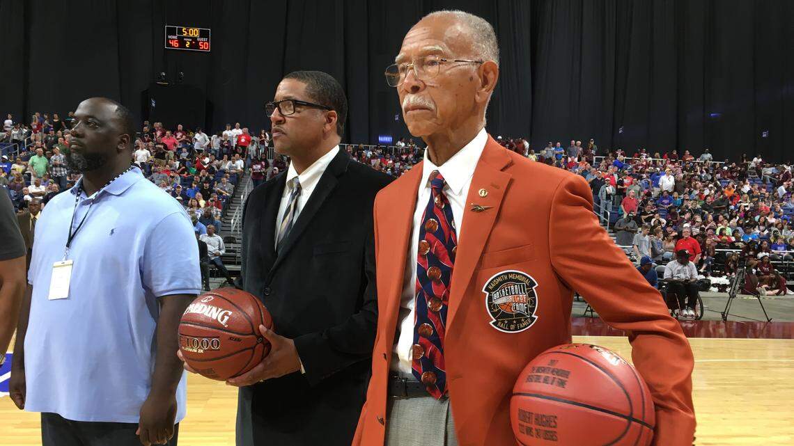 Sporting his Naismith Hall of Fame blazer, Robert Hughes attends the UIL boys state basketball tournament, March 10, 2018. From left is former Dunbar student Daniel Tate, and Robert Hughes Jr., the current Dunbar coach.