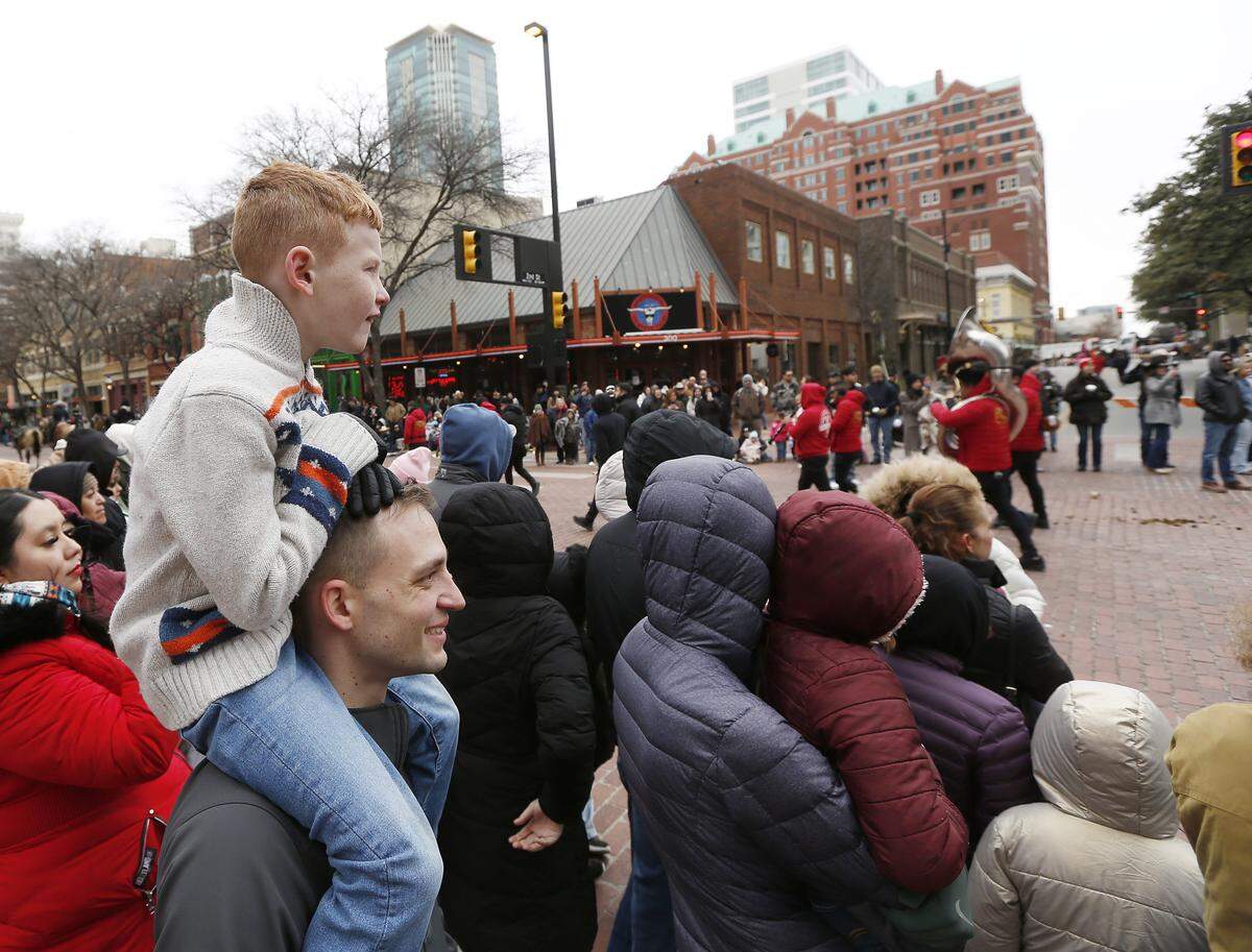 Josh Perkins hold his son Kaiper on his shoulders as the All-Western Parade passes by in downtown Fort Worth on Saturday, Jan. 17, 2026. 
