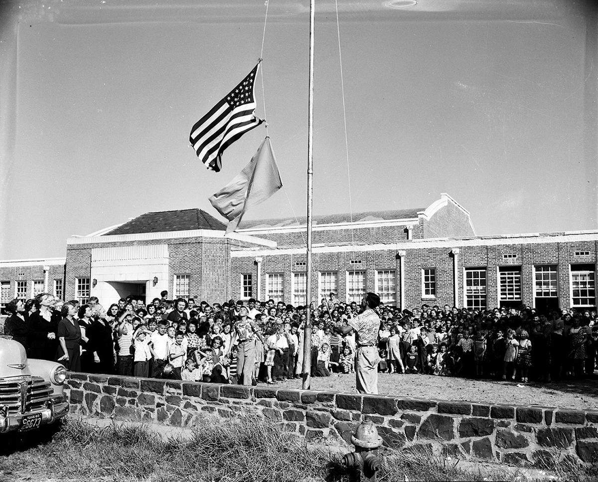 Oct. 24, 1950: Grapevine school students gathered outside the building to watch Harry Fielder, sophomore son of Mr. and Mrs. D. H. Fielder, raise the American and United Nations flags. Members of the Grapevine Home Demonstration Club made the U. N. banner and presented it to the school.