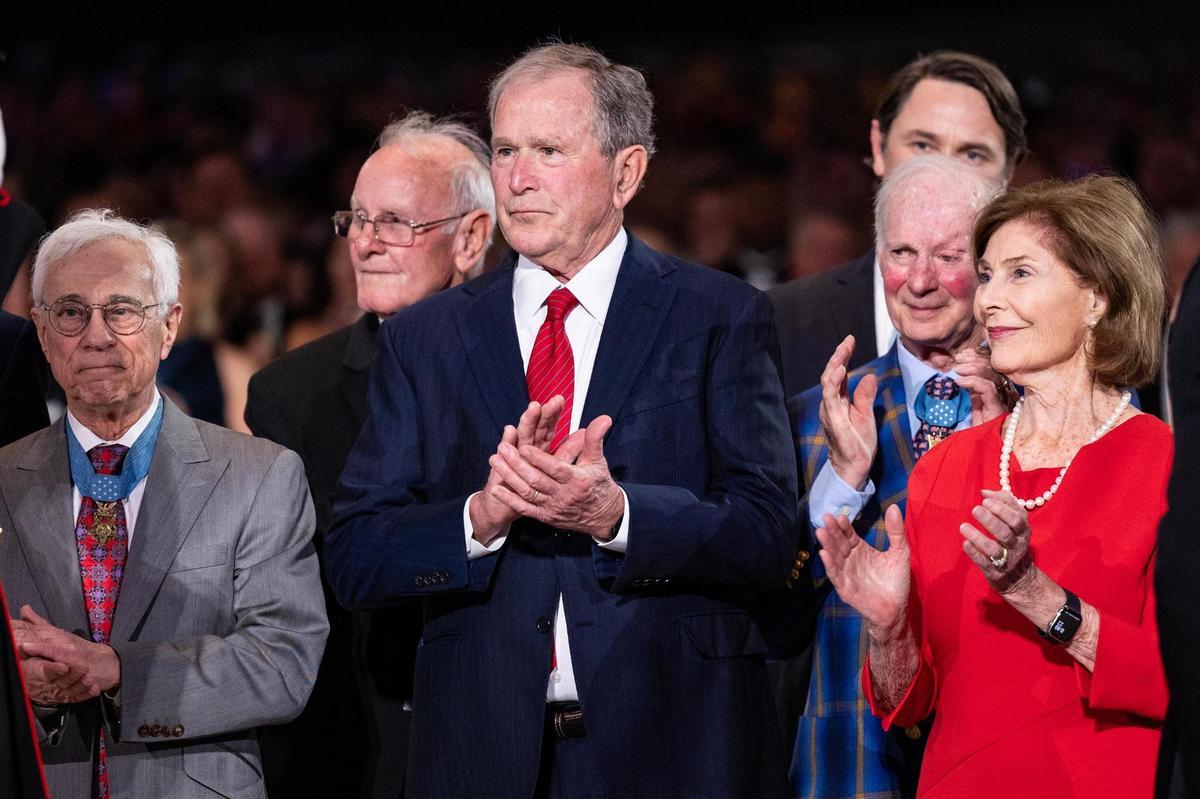 Former President George W. Bush and his wife Laura stand with Medal of Honor recipients for the ribbon cutting ceremony for the National Medal of Honor Museum Grand Opening Celebration in the Arlington Entertainment District on Saturday, March 22, 2025.