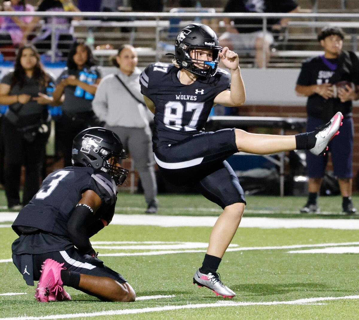 Timberview kicker Emma Young (87) kicks a pat held by quarterback Cameron Bates (3) in the first half of a UIL football game at Vernon Newsom Stadium in Mansfield, Texas, Thursday, Oct. 19, 2023.