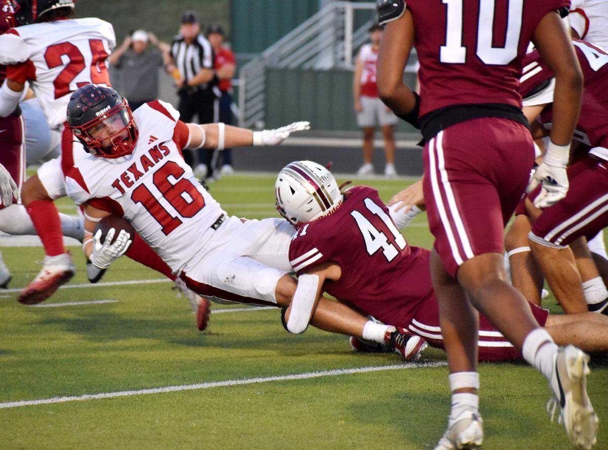 Justin Northwest’s Keegan Wells falls forward for yardage while being tackled by Keller Central’s Holden Myers during the first quarter of a UIL football game at KISD Athletic Complex on Thursday, Oct. 10, 2024.
