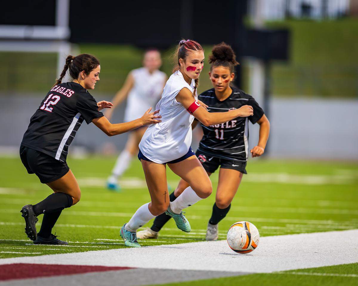 Grapevine’s Tatum Harig, center in white, battles for the ball against Argyle in the Class 5A Division 2 Region 1 Final soccer match on Tuesday, March 31, 2026, at Northwest ISD Stadium in Justin, Texas.