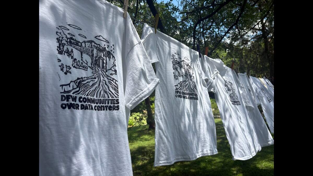 Block-printed T-shirts for the DFW Communities Over Data Centers organization hang from a drying line at Fort Worth’s Weston Gardens on Saturday June 6, 2026. Residents gathered at the gardens to express opposition over a proposed data center in the city.