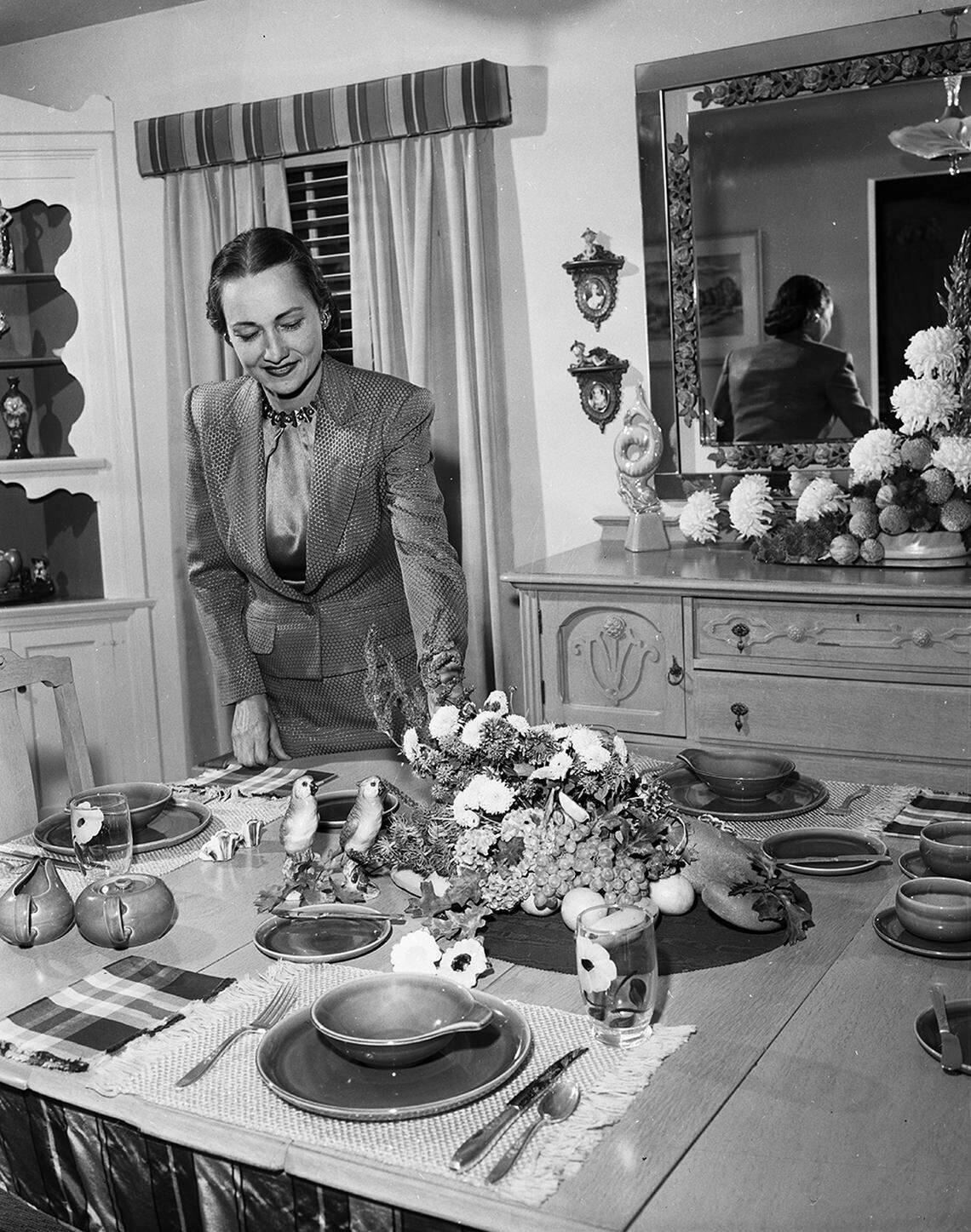Nov. 1, 1952: From a society series on Thanksgiving table settings. Autumn tones are used, with flowers, pottery and place mats, as Mrs. J.J. Hurley of 5001 Dexter tries out table decoration ideas for a holiday morning meal.