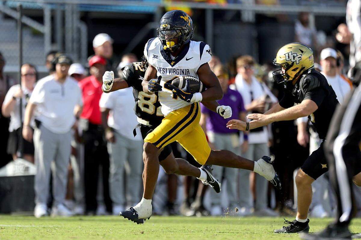 ORLANDO, FLORIDA - OCTOBER 18: Khalil Wilkins #14 of the West Virginia Mountaineers runs the ball in the third quarter of the game between the UCF Knights and West Virginia Mountaineers at FBC Mortgage Stadium on October 18, 2025 in Orlando, Florida. (Photo by Dustin Markland/Getty Images)