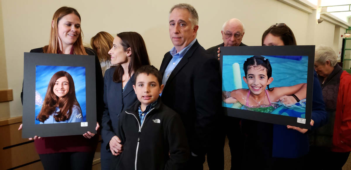 Lori Cerami, (second from left) the mother of teen who drowned at swim practice, is outside courtroom Friday with supporters holding pictures of her daughter. The teen’s assistant swim coach got probation on a neglect conviction