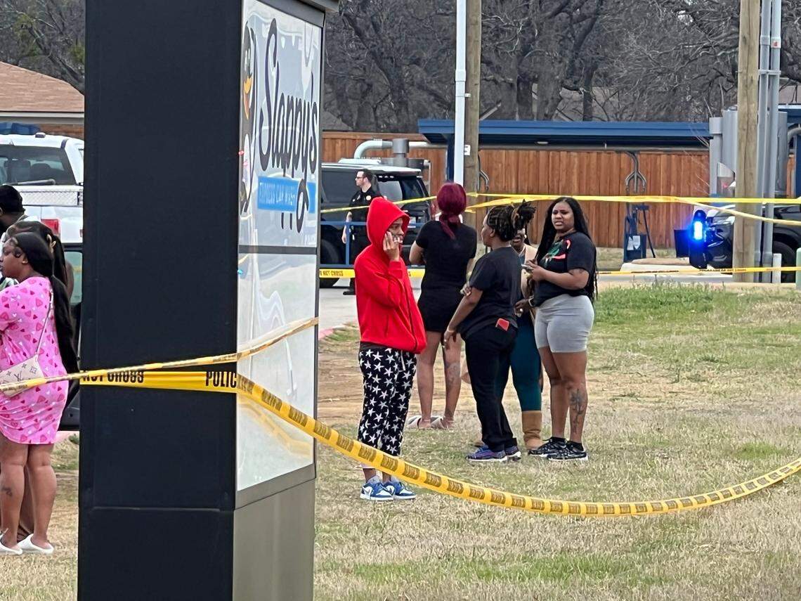 People gather Monday afternoon, March 3, at Slappy’s Car Wash, at 6500 Forest Hill Drive, where ambulances, Forest Hill police officers, Fort Worth police and firefighters, and the Tarrant County Sheriff’s Office responded to a fatal shooting.