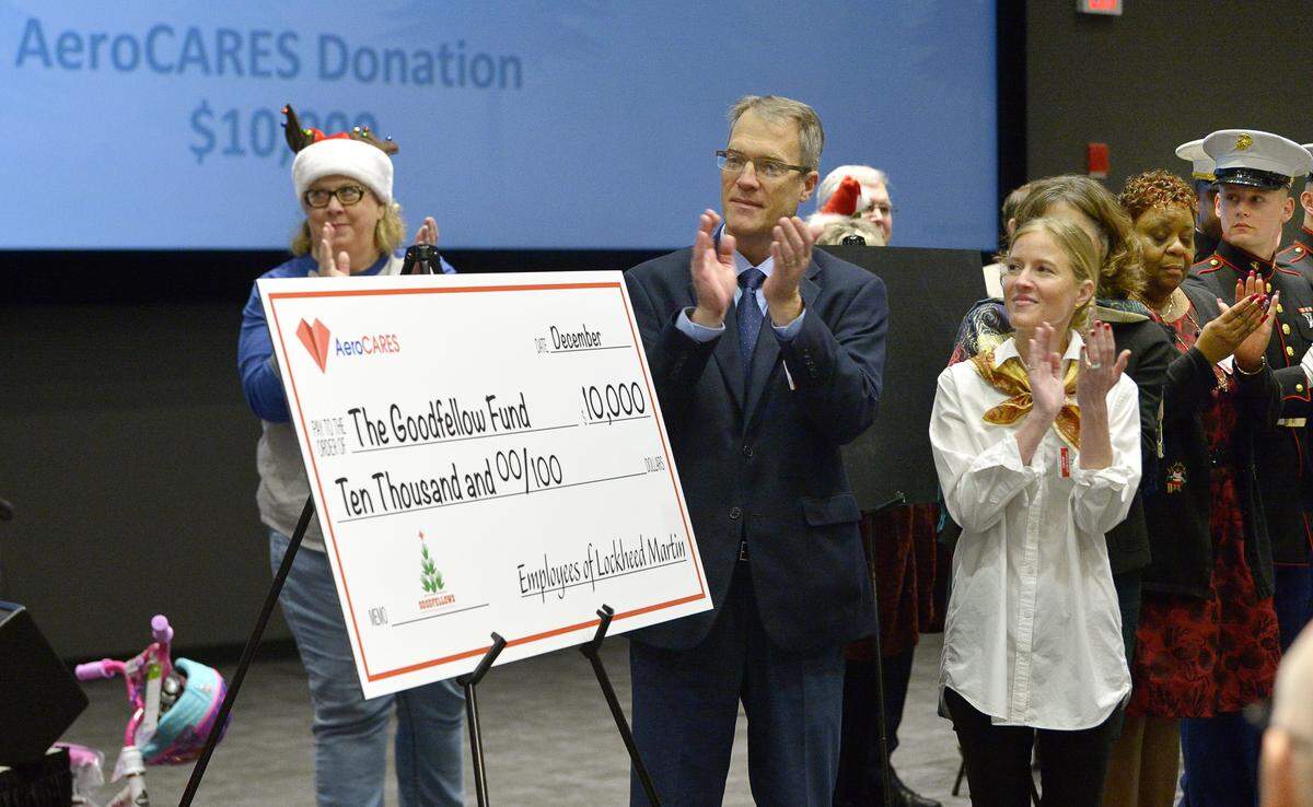 Fort Worth Star-Telegram editor Steve Coffman accepts a check for $10,000 for the Goodfellow Fund at the Lockheed Martin Holiday Charities Parade at Lockheed Martin Aeronautics in Fort Worth in 2018. 