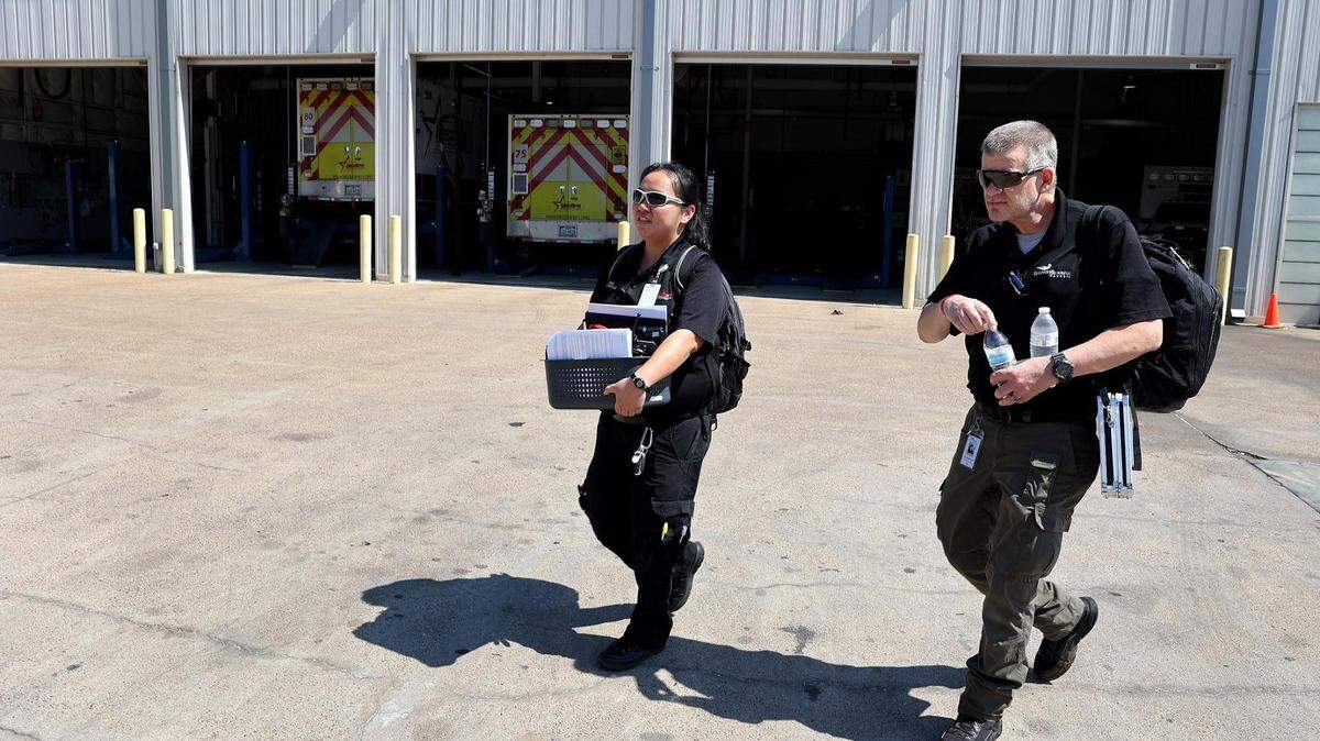 Amy Yang, a mobile health paramedic with MedStar, left, and Sean Southern, a peer recovery specialist with Recovery Resource Council, head out for a day of making visits to recent nonfatal overdose victims in July. The goal of the partnership is to offer resources to those suffering from substance use disorder who are ready to accept help.