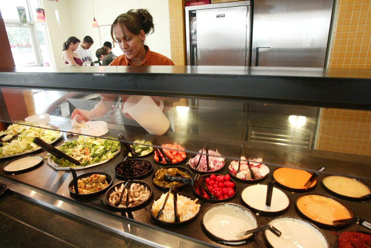 Raquel Tarin prepares the salad bar at Cicis Pizza in Fort Worth, Texas, on Wednesday, June 22, 2005.