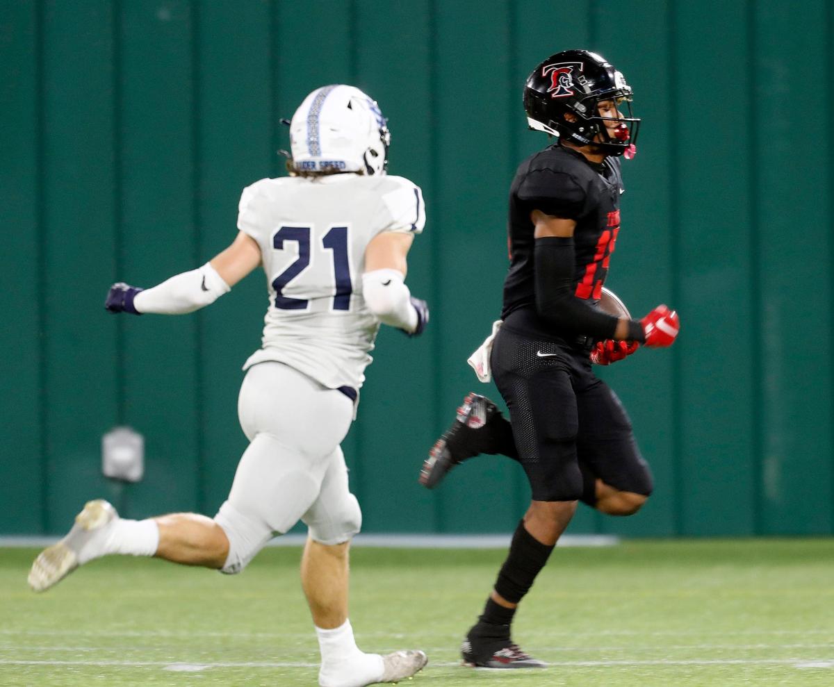 Trinity wide receiver Pofele Ashlock (15) scoots in for the third touchdown ahead of L.D. Bell defensive back Kyle Kamerer (21)during a high school football game at Globe Life Park in Arlington Texas, Thursday, Oct. 22, 2020. Trinity led 38-0 at the half. (Special to the Star-Telegram Bob Booth)