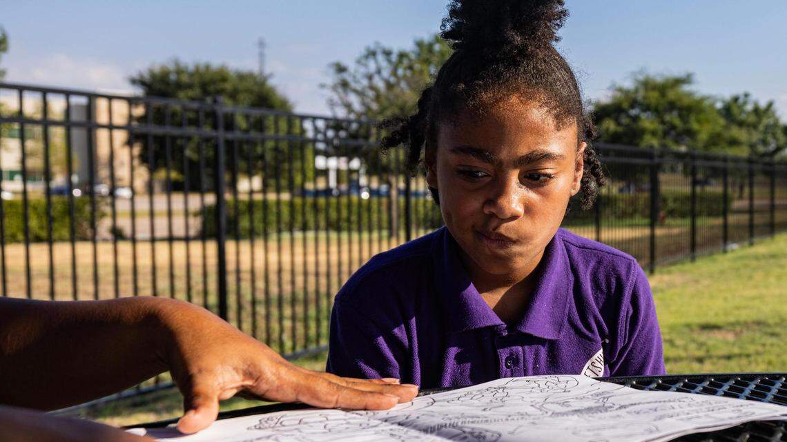 LaShanta Mire, left, helps her daughter Malaysia Campbell, 8, build her reading skills at the park in the Patriot Pointe Apartments in Fort Worth on Sept. 20, 2023. After taking a reading assessment over the summer, Malaysia, who is in the third grade, was told she has a kindergarten reading level despite coming home with A’s on her report cards.