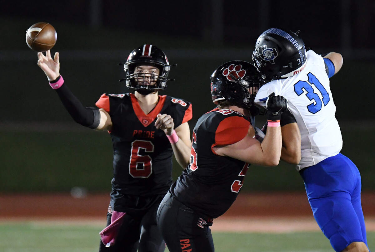 Colleyville Heritage quarterback Weston Smith, left, throws for a first down as Rhett Willmann blocks Mansfield Summit’s Maruio White in the fourth quarter of their district 4-5A Division 1 football game Friday, October 15, 2021 at Mustang-Panther Stadium in Grapevine, Texas. Heritage went on to win 35-34. Special/Bob Haynes
