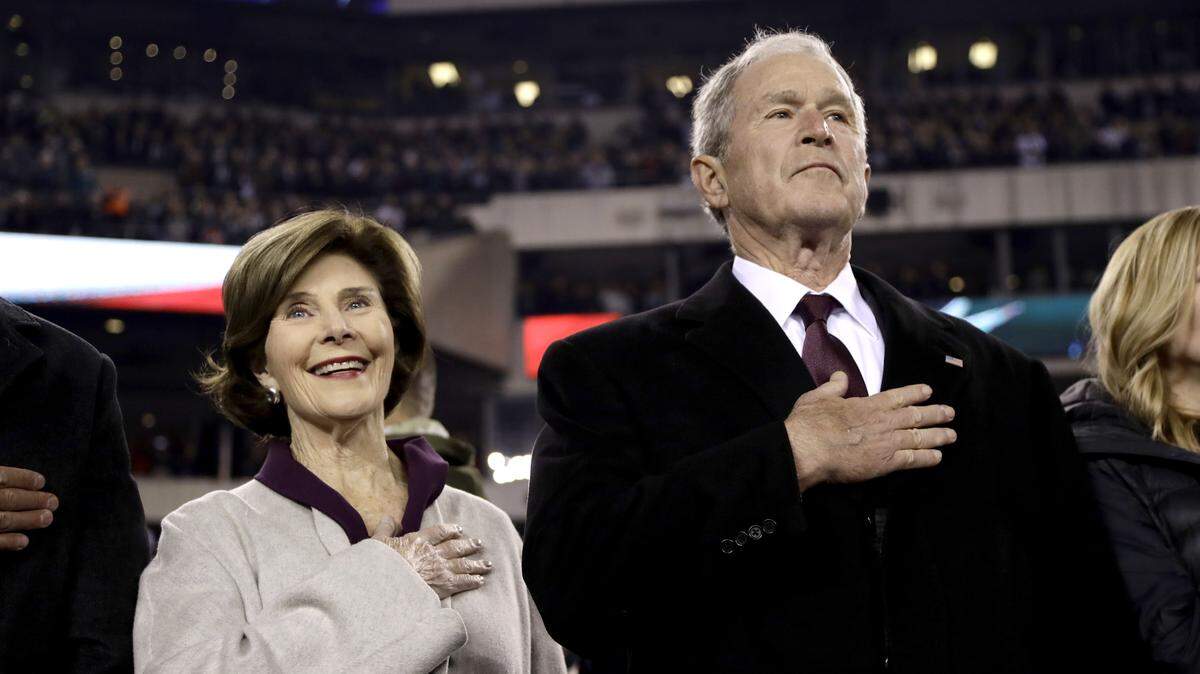 Former United States president George W. Bush, right, and his wife, former first lady Laura Bush, listen to the national anthem prior to Sunday night’s Philadelphia Eagles-Dallas Cowboys game in Philadelphia.