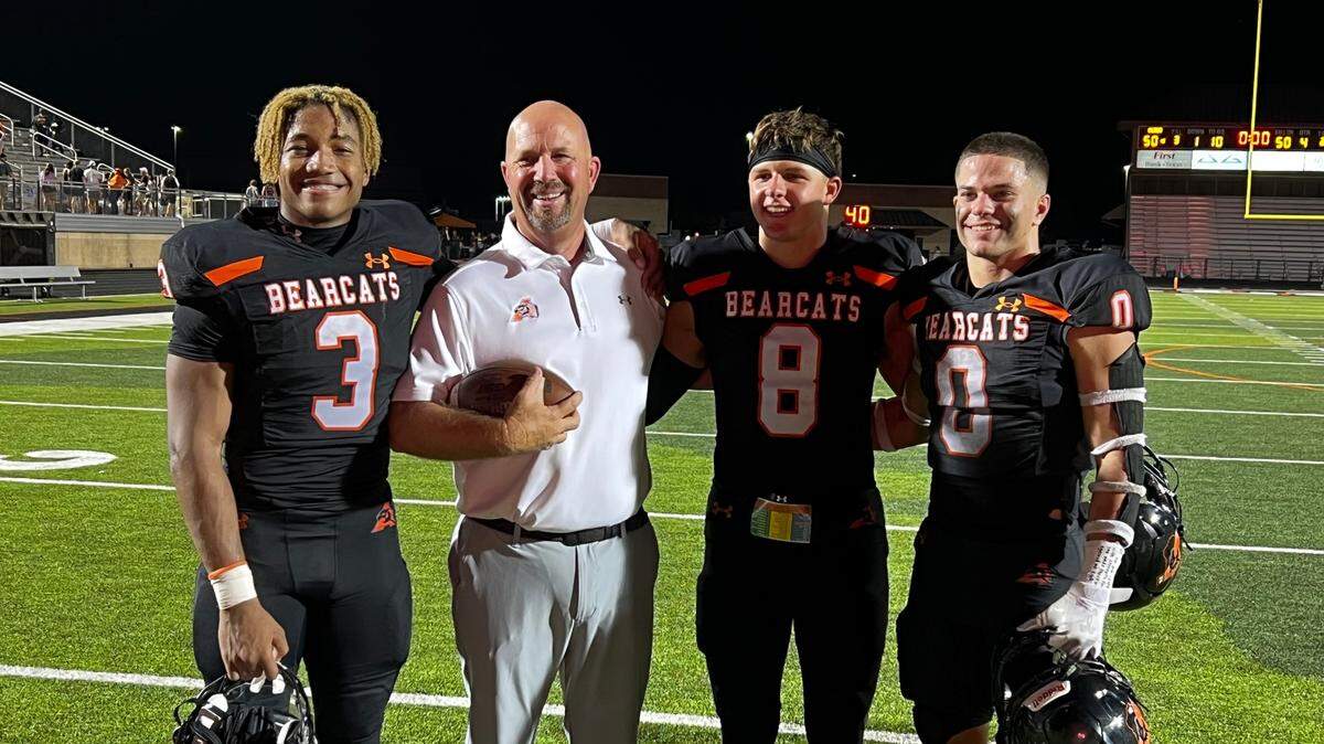 Aledo head coach Robby Jones and team captains Davhon Keys (3), Hauss Hejny (8) and Jake Gillespie (0) celebrate a win over Dallas Parish Episcopal with a photo.