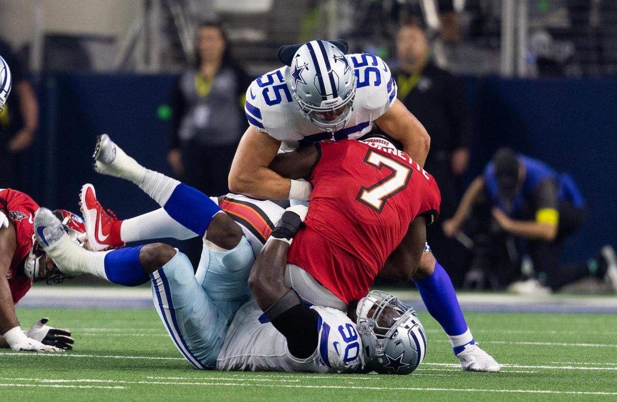 Dallas Cowboys DeMarcus Lawrence and Leighton Vander Esch tackle Tampa Bay Buccaneers Leonard Fournette on Sunday, September 11, 2022, at AT&T Stadium in Arlington.