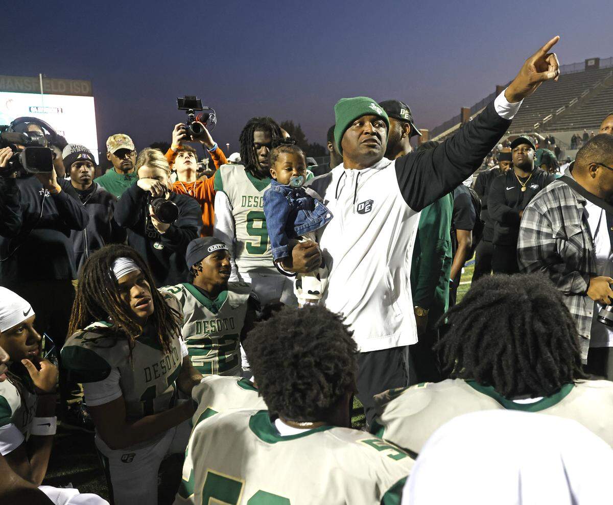 DeSoto head coach Claude Mathis points to the scoreboard as he talks to his team after it defeated Southlake Carroll in a Class 6A Division II state semifinal Saturday at Newsom Stadium in Mansfield.