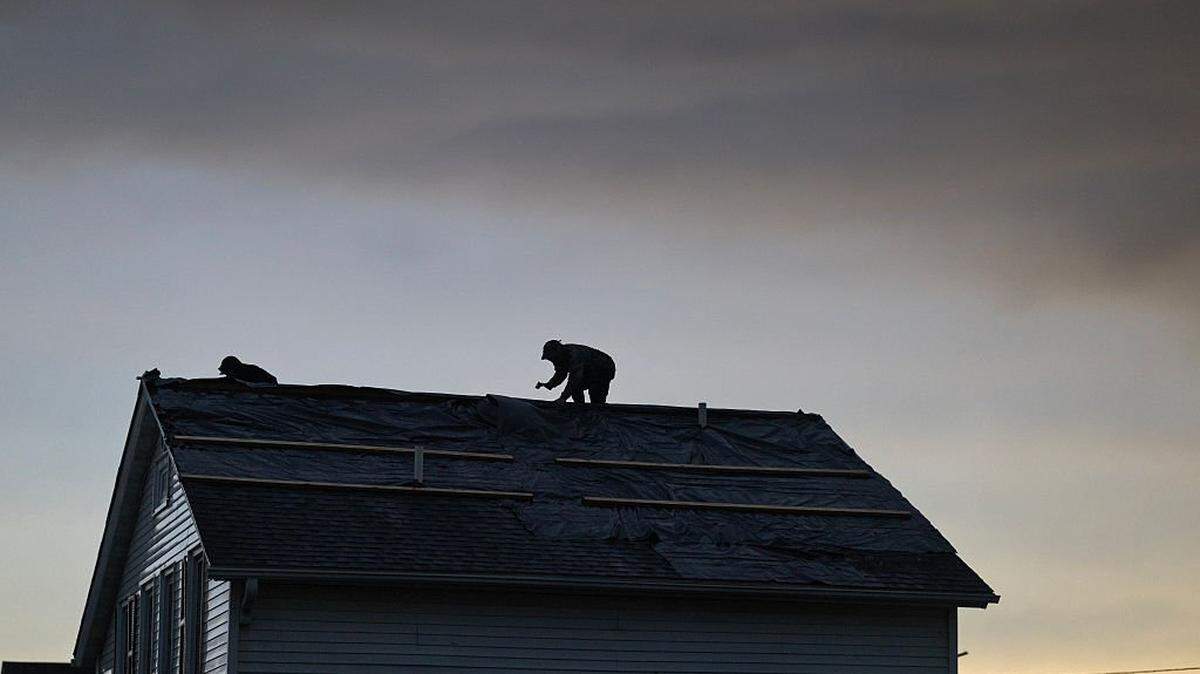 LENA, ILLINOIS - APRIL 17: Workers make repairs to a roof after a tornado passed through the center of town on April 17, 2026 in Lena, Illinois. The storm that passed through the area was part of a strong storm system that caused tornados in several states. (Photo by Scott Olson/Getty Images)