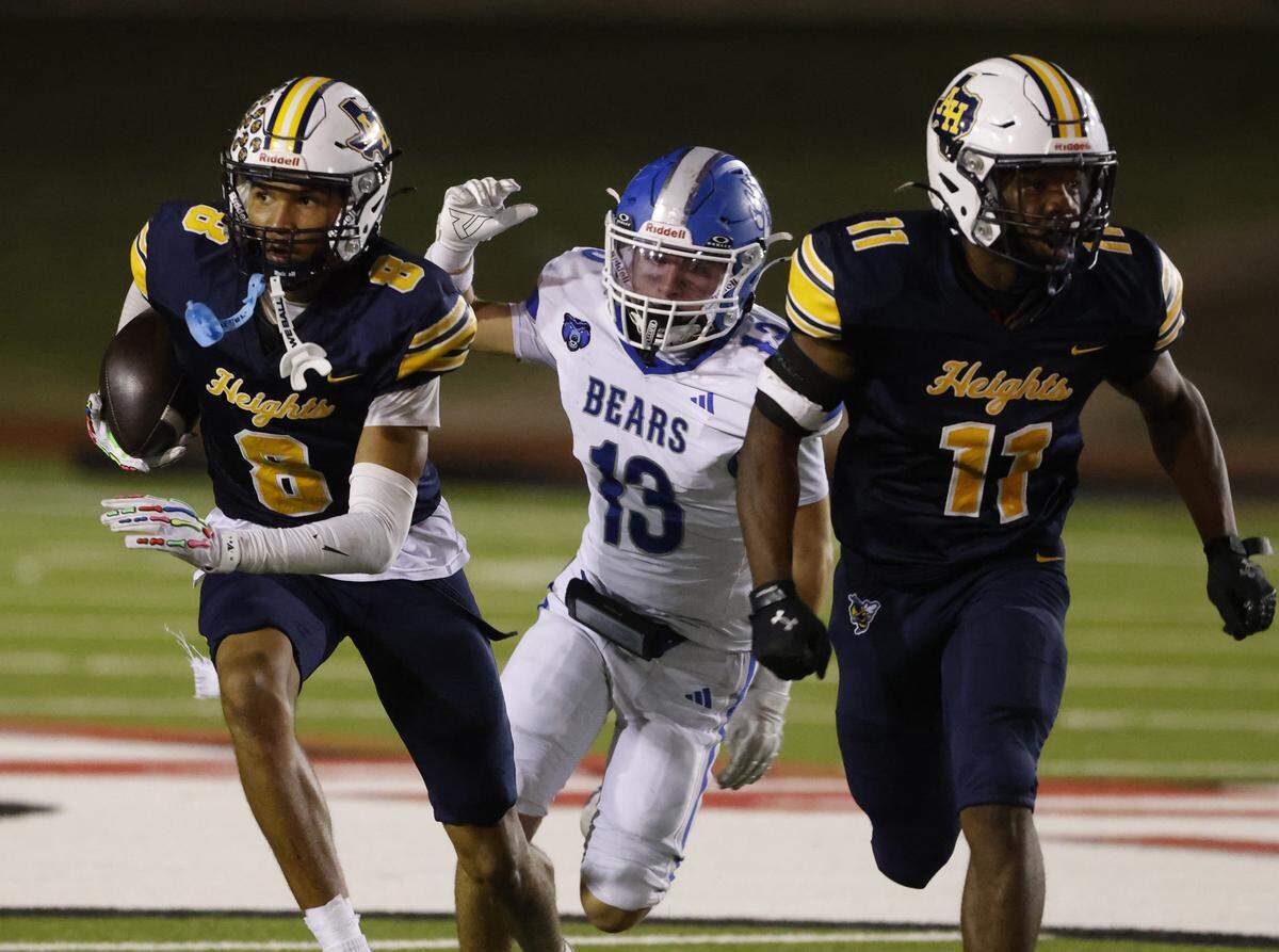 Arlington Heights defensive back TJ Johnson (8) returns an interception intended for Brewer wide receiver Andrew Jones (13) during the second half of a Class 5A Division I bi-district playoff game Nov. 14 at Farrington Field in Fort Worth.