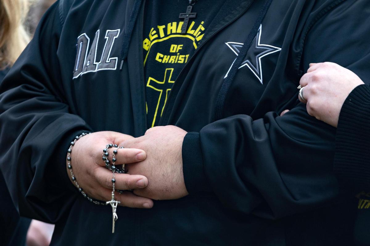 A man holds a a rosary during prayer at a vigil for Ja’Shawn James Poirier on Tuesday, March 21, 2023, in Arlington. Poirier, 16, was shot by a classmate at Lamar High on Monday, police said.