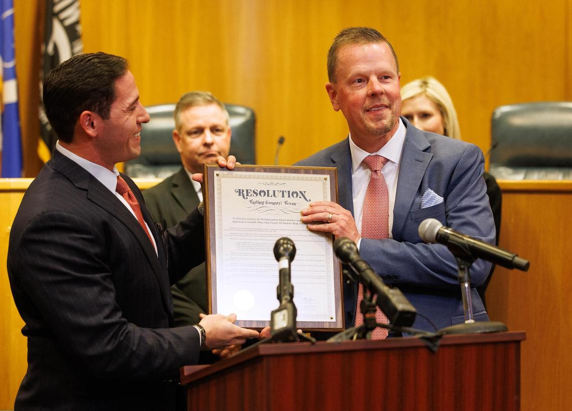 Tarrant County Commissioner Manny Ramirez, left, presents a resolution to prioritize literacy in all independent school districts in the county to Eagle Mountain-Saginaw ISD Superintendent Jerry Hollingsworth on Wednesday, Feb. 19.