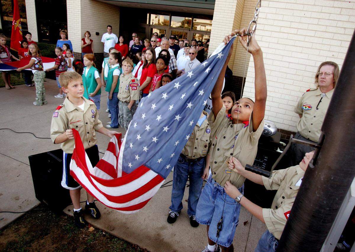 Nov. 10, 2006: Sixth-graders Quentin Query, left, and DeShane Hall with Boy Scouts Troop 76 raise the flag as the student body at Little Elementary School in Arlington gathered for a Veteran’s Day ceremony.