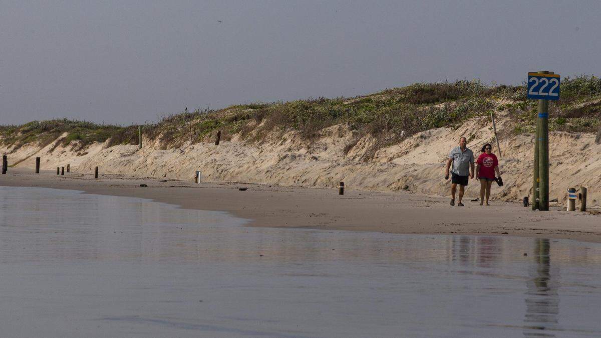 People walk along the beach next dunes at Whitecap Beach on Sunday, Sept. 20, 2020.
