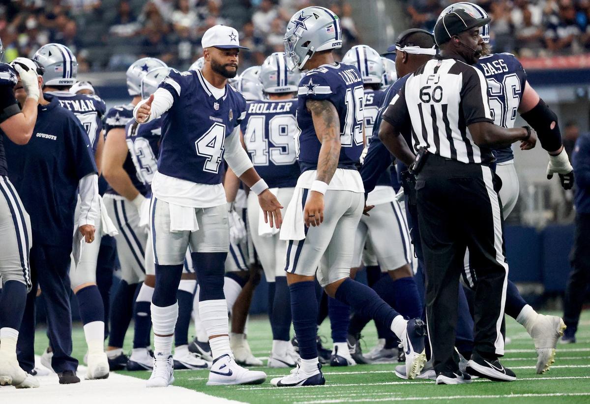 Dallas Cowboys quarterback Dak Prescott (4) high-fives Trey Lance (19) after Lance passed for a touchdown during the second quarter against the Los Angeles Chargers during the NFL preseason on Saturday at AT&T Stadium in Arlington.